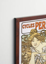 Aranżacja wnętrza, na ścianie wisi plakat w ramce: Cycles Perfecta Alfons Mucha secesja kobieta rower