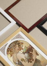 Zbliżenie na detale plakatu oprawionego w drewnianą białą ramkę od Plakatello®: Alfons Mucha kobieta jesień winogrona secesja