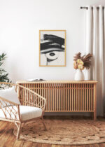 Aranżacja wnętrza, na ścianie wisi plakat w ramce w naturalnym kolorze drewna (plakat i ramka od Plakatello®)