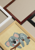 Widok z góry na cztery drewniane ramki, w jednej z nich oprawiony plakat do pokoju dziecięcego koala na gałęzi eukaliptusa pastelowe kolory