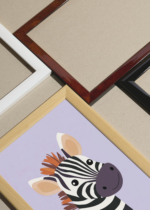 Widok z góry na cztery drewniane ramki, w jednej z nich oprawiony plakat do pokoju dziecięcego zebra z kolorową grzywą skandynawski