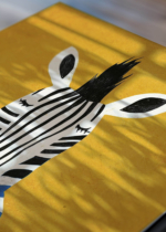 Zbliżenie na detale plakatu: zebra w swetrze z kawą na żółtym tle do pokoju dziecięcego