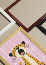 Widok z góry na cztery drewniane ramki, w jednej z nich oprawiony plakat do pokoju dziecięcego ziewający gepard safari