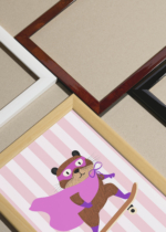 Widok z góry na cztery drewniane ramki, w jednej z nich oprawiony plakat gryzoń superbohater na deskorolce na tle w różowe paski do pokoju dziecięcego