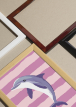 Widok z góry na cztery drewniane ramki, w jednej z nich oprawiony plakat delfin pastelowy skandynawski do pokoju dziecięcego