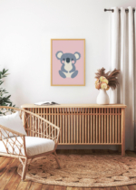 Aranżacja wnętrza, na ścianie wisi plakat w ramce: koala na różowym tle do pokoju dziecięcego