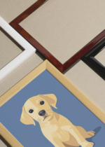 Widok z góry na cztery drewniane ramki, w jednej z nich oprawiony plakat młody labrador na błękitnym tle do pokoju dziecięcego