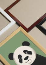 Widok z góry na cztery drewniane ramki, w jednej z nich oprawiony plakat do pokoju dziecięcego panda wielka skandynawski