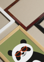 Widok z góry na cztery drewniane ramki, w jednej z nich oprawiony plakat panda w pomarańczowych okularach na zielonym tle do pokoju dziecięcego