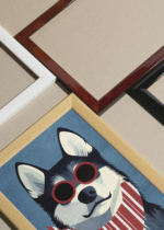 Widok z góry na cztery drewniane ramki, w jednej z nich oprawiony plakat pies husky w czerwonych okularach do pokoju dziecięcego