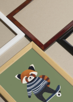 Widok z góry na cztery drewniane ramki, w jednej z nich oprawiony plakat czerwona panda na deskorolce do pokoju dziecięcego