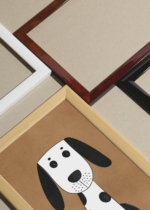 Widok z góry na cztery drewniane ramki, w jednej z nich oprawiony plakat pies czarno-biały do pokoju dziecięcego