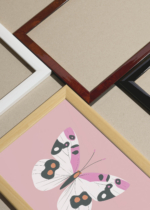 Widok z góry na cztery drewniane ramki, w jednej z nich oprawiony plakat motyl na różowym tle minimalistyczny do pokoju dziecięcego