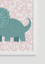 Zbliżenie na detale plakatu oprawionego w drewnianą białą ramkę od Plakatello®: dinozaur triceratops retro do pokoju dziecięcego