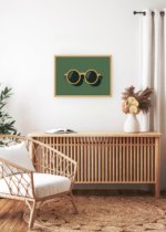 Aranżacja wnętrza, na ścianie wisi plakat w ramce: okulary przeciwsłoneczne na zielonym tle retro