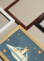 Widok z góry na cztery drewniane ramki, w jednej z nich oprawiony plakat piesek corgi w statku UFO kosmos gwiazdy do pokoju dziecięcego