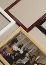 Widok z góry na cztery drewniane ramki, w jednej z nich oprawiony plakat Edgar Degas Skład bawełny w Nowym Orleanie 1873