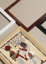 Widok z góry na cztery drewniane ramki, w jednej z nich oprawiony plakat egipski kapłan ceremonia Belzoni 1820