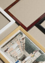 Widok z góry na cztery drewniane ramki, w jednej z nich oprawiony plakat Świątynia egipska Belzoni odkrycia archeologiczne