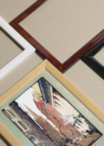 Widok z góry na cztery drewniane ramki, w jednej z nich oprawiony plakat Trinity Church Wall Street Nowy Jork 1916