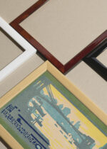 Widok z góry na cztery drewniane ramki, w jednej z nich oprawiony plakat Brooklyn Bridge późnym popołudniem Nowy Jork vintage