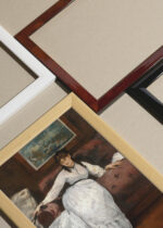 Widok z góry na cztery drewniane ramki, w jednej z nich oprawiony plakat Édouard Manet kobieta w białej sukni klasyczny