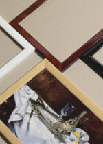 Widok z góry na cztery drewniane ramki, w jednej z nich oprawiony plakat Martwa natura z łososiem Édouard Manet reprodukcja