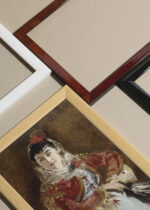 Widok z góry na cztery drewniane ramki, w jednej z nich oprawiony plakat Édouard Manet Portret Emilie Ambre w roli Carmen 1879