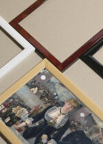 Widok z góry na cztery drewniane ramki, w jednej z nich oprawiony plakat A Bar at the Folies-Bergère (1882) Édouard Manet