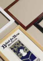 Widok z góry na cztery drewniane ramki, w jednej z nich oprawiony plakat Ethel Reed Behind the Arras kobieta kwiaty hibiskusa