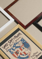 Widok z góry na cztery drewniane ramki, w jednej z nich oprawiony plakat Uncle Sam's Church Ethel Reed vintage USA