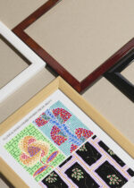 Widok z góry na cztery drewniane ramki, w jednej z nich oprawiony plakat E.A. Séguy Floreal Art Déco wzory geometryczne