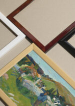 Widok z góry na cztery drewniane ramki, w jednej z nich oprawiony plakat Bretagne Paul Gauguin Pont-Aven pasterz owce