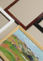 Widok z góry na cztery drewniane ramki, w jednej z nich oprawiony plakat Paysage près de Pont-Aven Paul Gauguin 1888