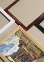 Widok z góry na cztery drewniane ramki, w jednej z nich oprawiony plakat Paul Gauguin Pont-Aven bretońska uliczka 1888