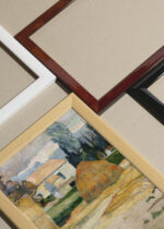 Widok z góry na cztery drewniane ramki, w jednej z nich oprawiony plakat Paul Gauguin pejzaż wiejski chaty stóg siana