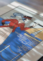 Widok z góry na cztery drewniane ramki, w jednej z nich oprawiony plakat Kostium jachtowy George Barbier 1914 Art Deco