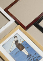 Zbliżenie na detale plakatu oprawionego w drewnianą białą ramkę od Plakatello®: Art Deco kobieta na plaży George Barbier 1913