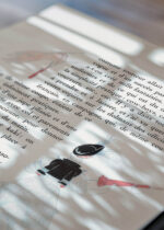 Widok z góry na cztery drewniane ramki, w jednej z nich oprawiony plakat kobieta z różową parasolką Art Deco George Barbier