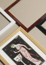 Zbliżenie na detale plakatu oprawionego w drewnianą białą ramkę od Plakatello®: Art Deco kobieta w jedwabnej sukni George Barbier