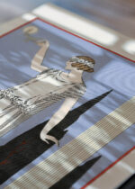 Widok z góry na cztery drewniane ramki, w jednej z nich oprawiony plakat Psyché George Barbier ilustracja mody Art Deco