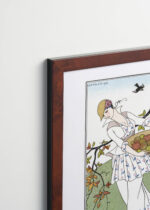 Aranżacja wnętrza, na ścianie wisi plakat w ramce: Art Deco George Barbier kobieta w ogrodzie 1914