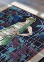 Widok z góry na cztery drewniane ramki, w jednej z nich oprawiony plakat Art Déco Des Roses dans la Nuit George Barbier