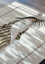 Widok z góry na cztery drewniane ramki, w jednej z nich oprawiony plakat Art Deco George Barbier moda kobieta futro 1912