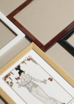 Zbliżenie na detale plakatu oprawionego w drewnianą białą ramkę od Plakatello®: Tancerka w czarnym kapeluszu Art Deco George Barbier