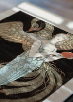 Widok z góry na cztery drewniane ramki, w jednej z nich oprawiony plakat Sortilèges George Barbier 1925 Art Deco kobieta