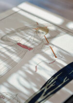 Widok z góry na cztery drewniane ramki, w jednej z nich oprawiony plakat Le Cyprès et la Rose George Barbier art déco