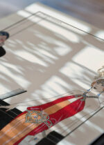 Widok z góry na cztery drewniane ramki, w jednej z nich oprawiony plakat Incantation Zaklęcie George Barbier Art Deco 1922