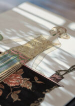 Widok z góry na cztery drewniane ramki, w jednej z nich oprawiony plakat Art Deco Rosalinde George Barbier 1922 moda