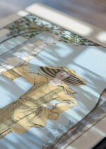 Widok z góry na cztery drewniane ramki, w jednej z nich oprawiony plakat Amalfi George Barbier art déco kobieta vintage